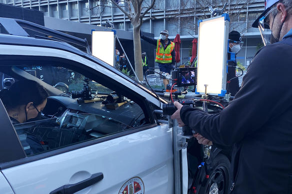 Crewmember sets up a BGH1 on a camera tray on a police car