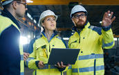 three warehouse workers discuss their work