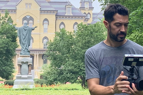 Johnny Derango shooting handheld with the GH5 II in front of Notre Dame University