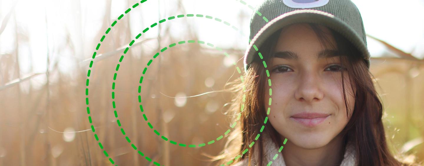 Girl with a cap on in a field