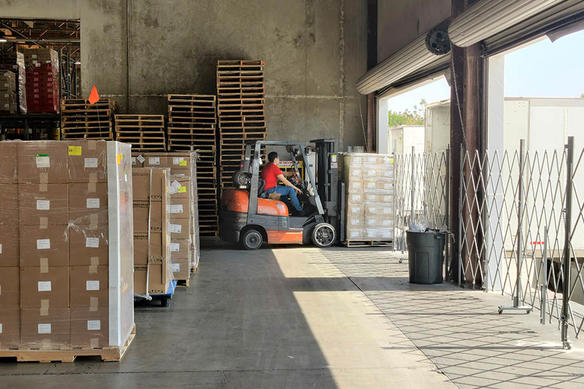 a man operates a forklift inside a warehouse