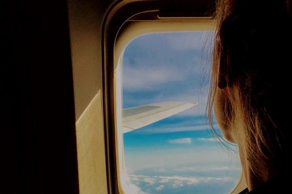 a woman looks out an airplane window