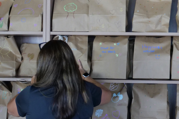 A Panasonic employee volunteer packs bags with presents for children in need